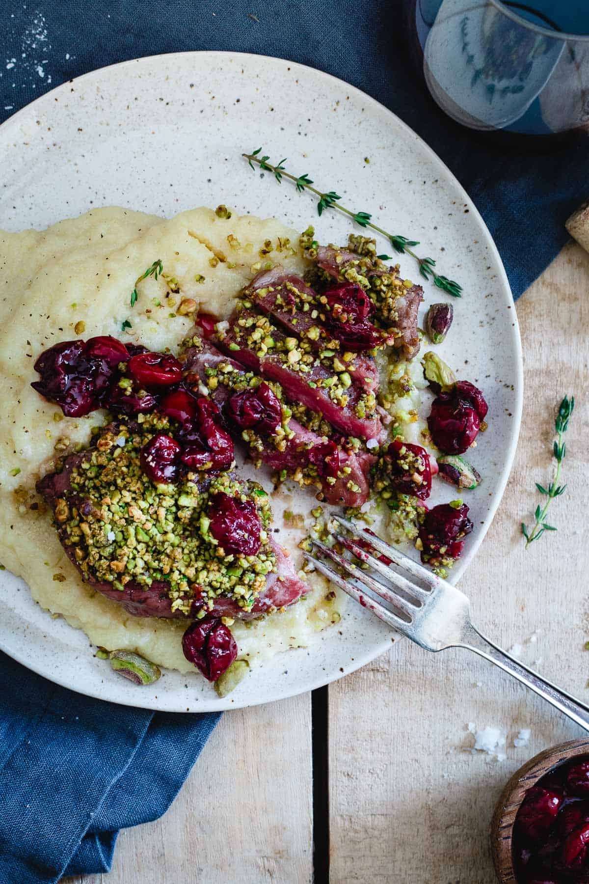 Red wine cherries and creamy parmesan polenta take these pistachio crusted lamb chops to the next level!