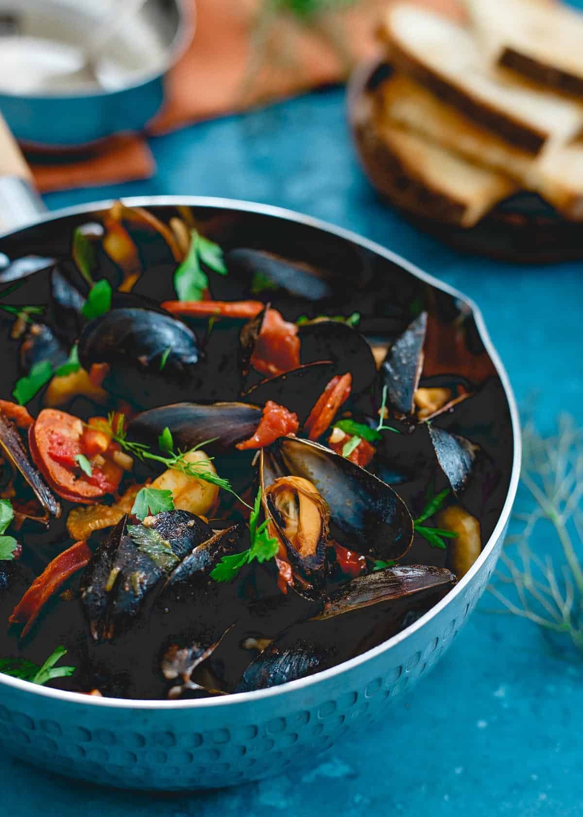 These spicy chorizo mussels are an easy, one pot meal made in 20 minutes with spicy dried chiles, fennel and chorizo in a chunky tomato broth. Serve with some warm crusty bread for a seafood feast!