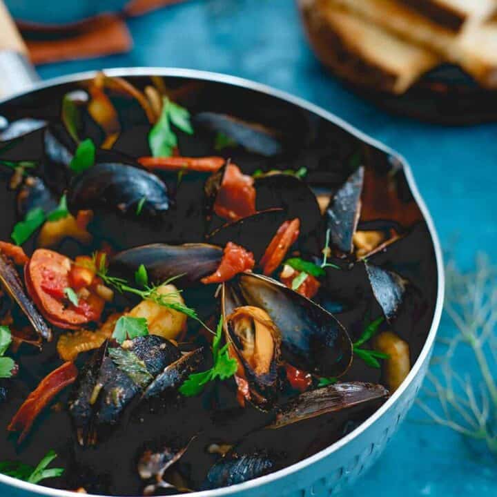 These chorizo chili mussels are an easy, one pot meal made in 20 minutes with spicy dried chilis, fennel and chorizo in a chunky tomato broth. Serve with some warm crusty bread for a seafood feast!