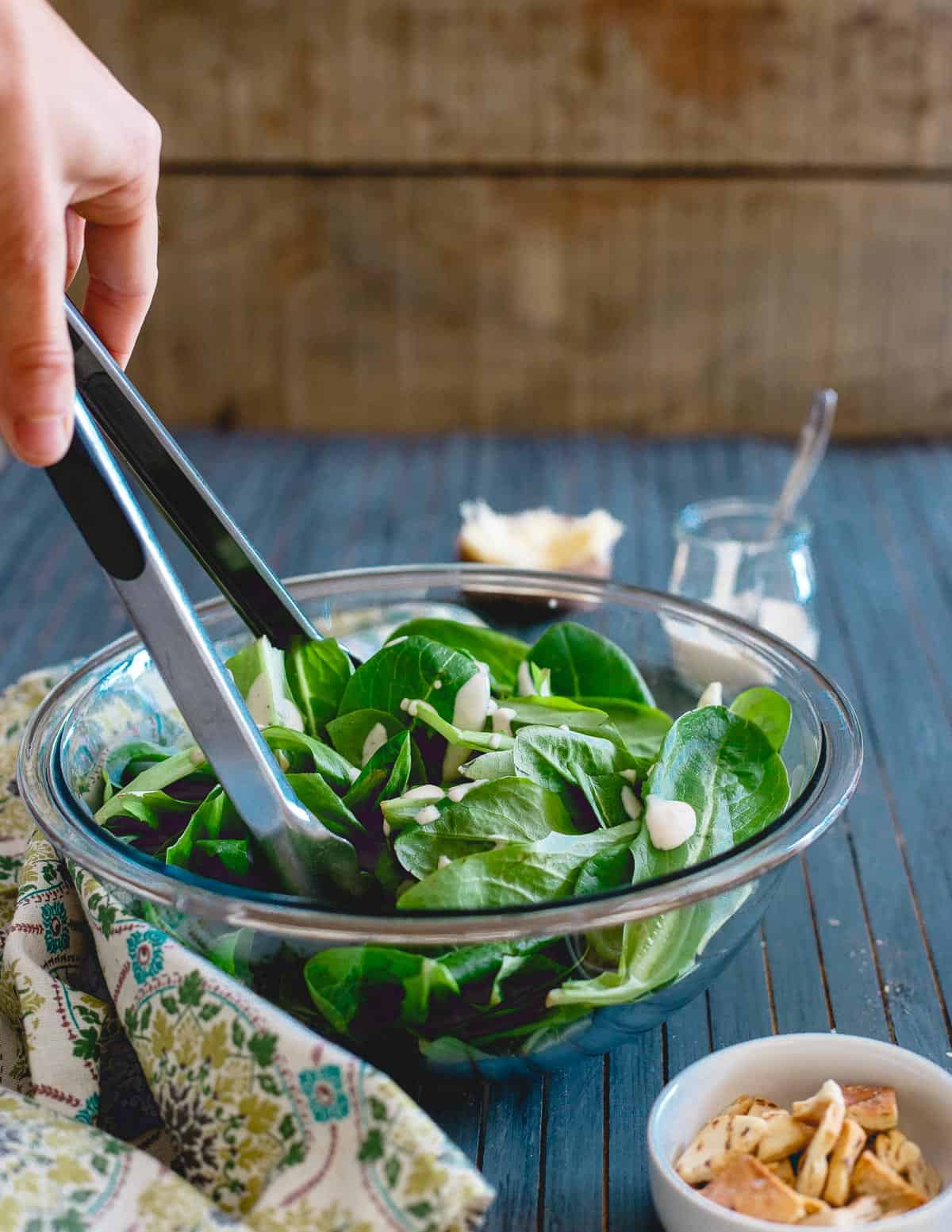 Fresh baby spinach and romaine gets tossed with creamy caesar dressing, pita chips and parmesan before getting stuffed in sweet potatoes for an easy meal!