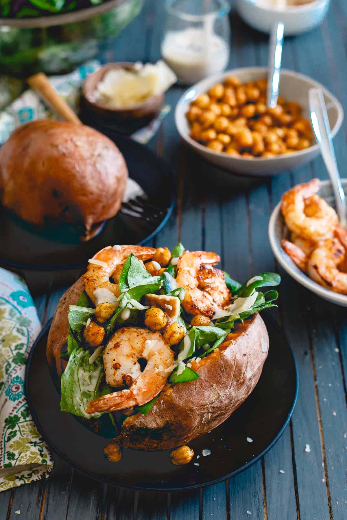 Topped with spicy cooked shrimp and roasted chickpeas, these caesar salad stuffed sweet potatoes are a healthy, complete meal!