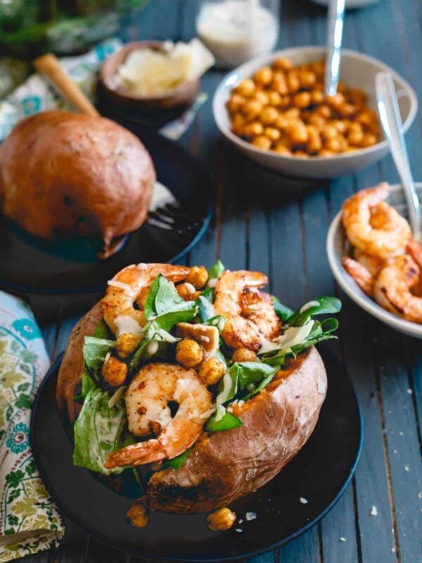 Topped with spicy cooked shrimp and roasted chickpeas, these caesar salad stuffed sweet potatoes are a healthy, complete meal!