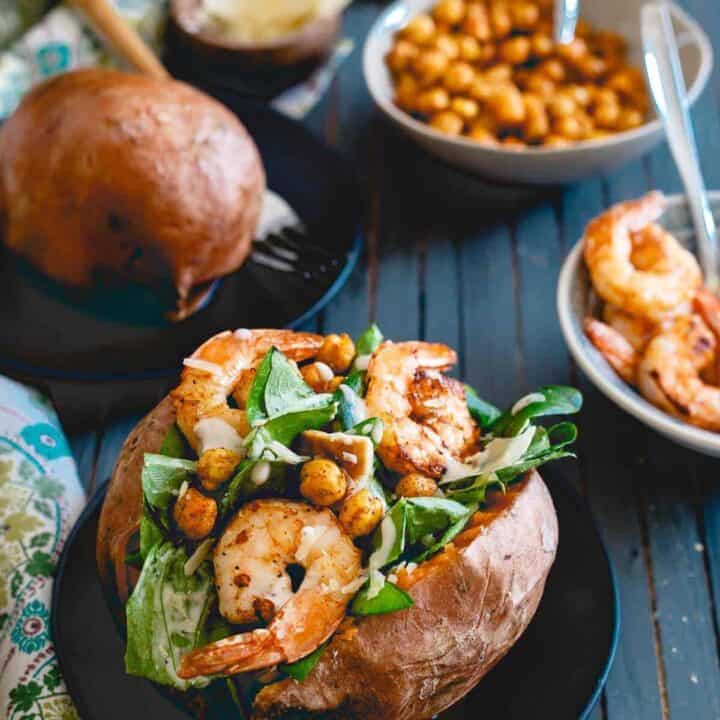 Topped with spicy cooked shrimp and roasted chickpeas, these caesar salad stuffed sweet potatoes are a healthy, complete meal!