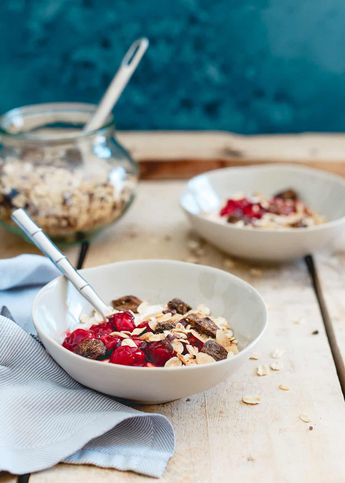 These breakfast yogurt bowls are topped with a tart cherry ginger muesli. Loaded with oats, almonds, cacao nibs, ginger, dried tart cherries and warm spices. With a swirl of cherry sauce, it's a tasty and nutritious way to start the day. 