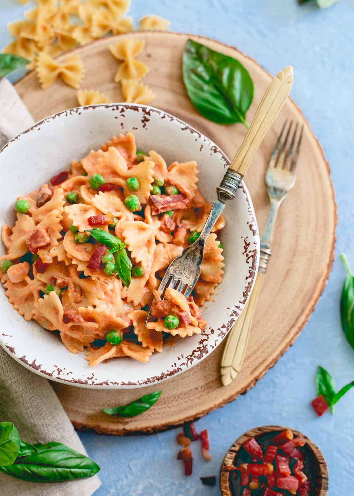 This 20 minute creamy tomato farfalle brings a healthy spin to traditional cream sauce with peas and crispy prosciutto for an easy, filling meal.