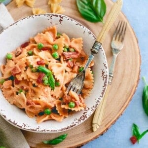 This 20 minute creamy tomato farfalle brings a healthy take on traditional cream sauce with peas and crispy prosciutto for an easy, filling meal.