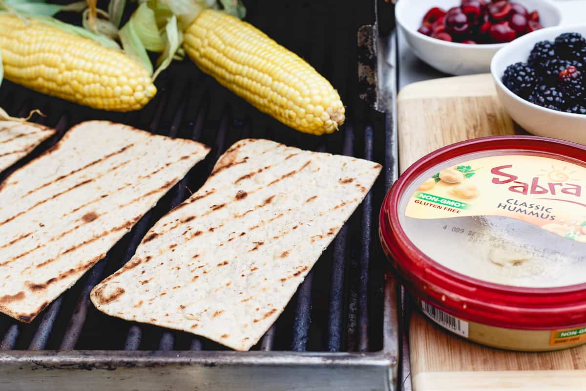 Grilled corn, berries, fresh cherries and hummus make a delicious flatbread for summer dining.