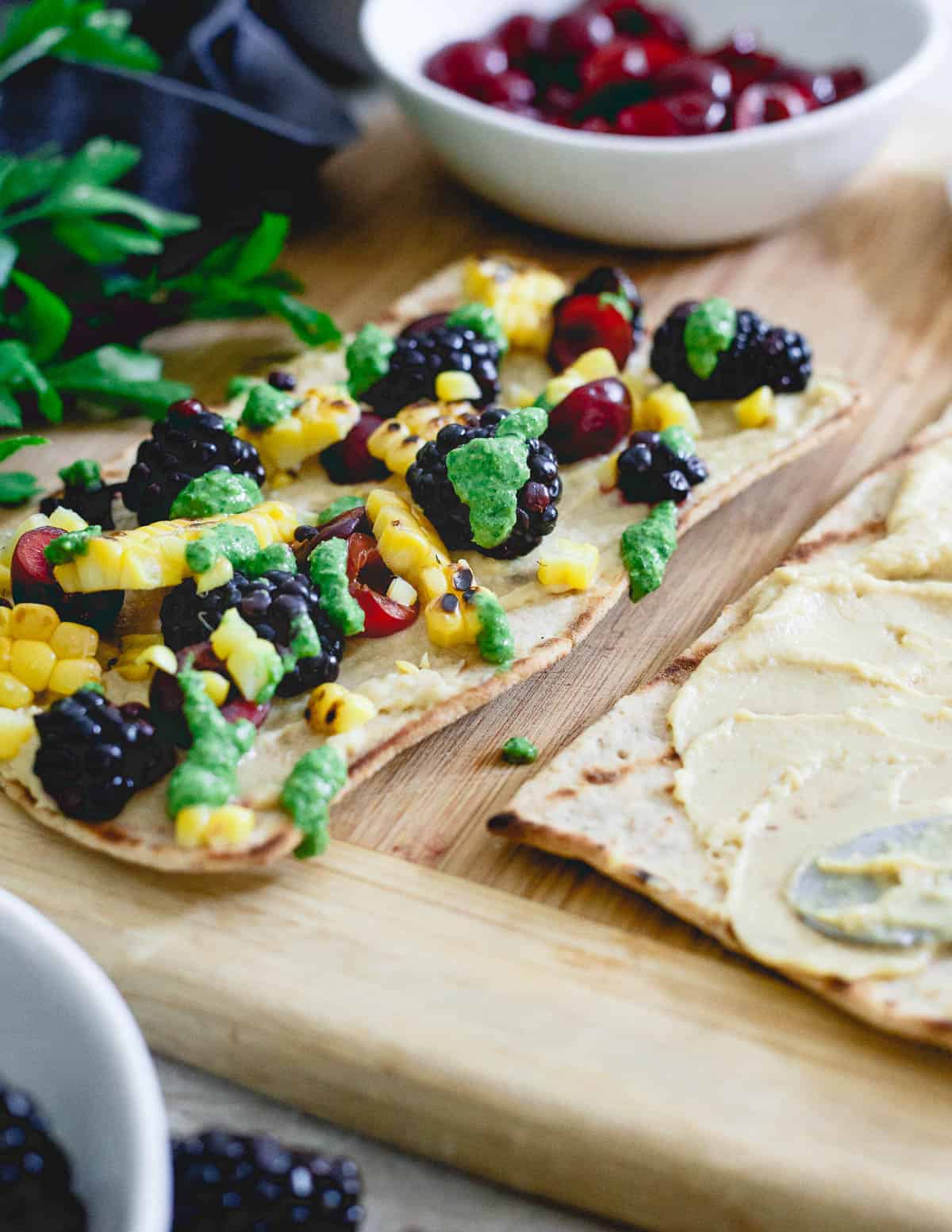 Topped with a fresh parsley pesto, these grilled hummus flatbreads are the perfect unofficial meal for snacking before dinnertime!