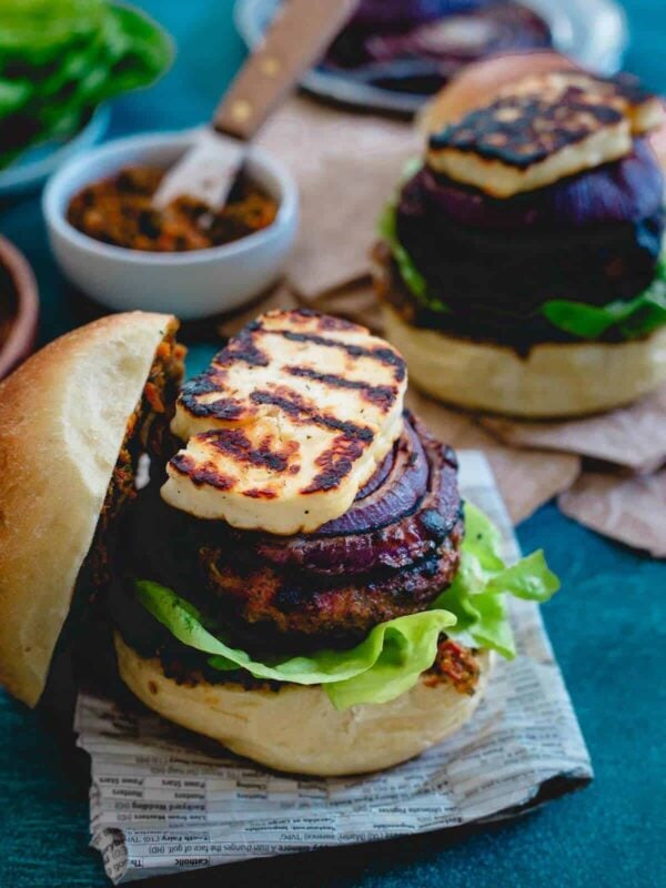 This grilled halloumi lamb burger is packed with fresh herbs, topped with red onions caramelized on the grill until sweet and a thick layer of sun-dried tomato pesto spread making each bite burst with delicious Mediterranean flavors.