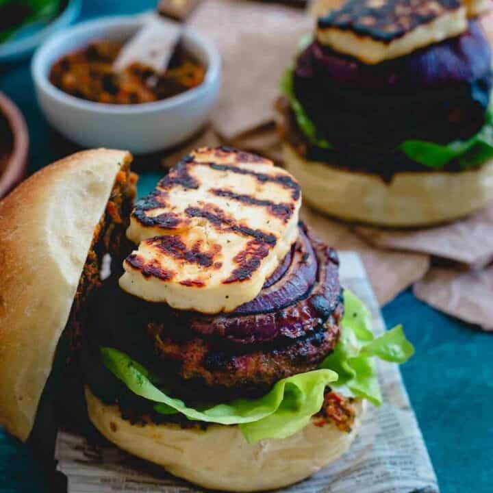 This grilled halloumi lamb burger is packed with fresh herbs, topped with red onions caramelized on the grill until sweet and a thick layer of sun-dried tomato pesto spread making each bite burst with delicious Mediterranean flavors.