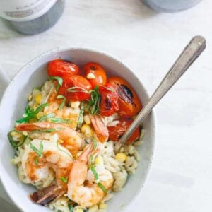 This brown butter shrimp is served on top of a creamy parmesan basil corn orzo and blistered cherry tomatoes for the perfect summer date night meal.