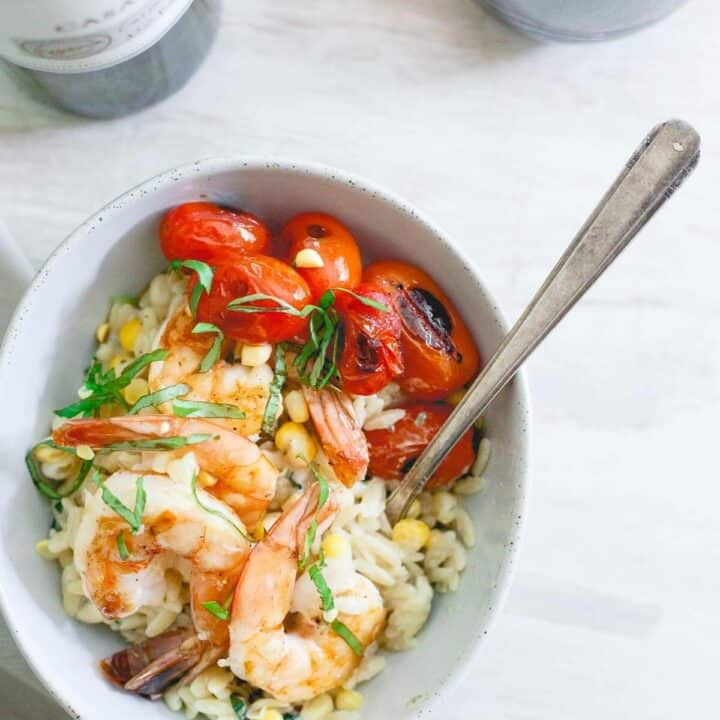 This brown butter shrimp is served on top of a creamy parmesan basil corn orzo and blistered cherry tomatoes for the perfect summer date night meal.