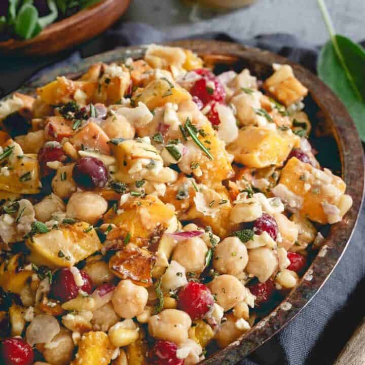 This chickpea fall salad is a hearty vegetarian meal with roasted sweet potatoes, delicata squash, cranberries, feta and a maple tahini dressing.