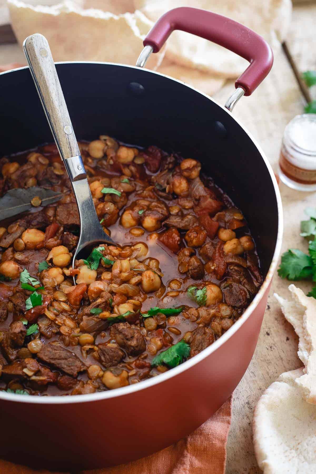 This lamb lentil stew is flavored with Moroccan spices and beefed up with chickpeas. Serve with fresh cilantro and a dollop of yogurt for a hearty and comforting winter meal.