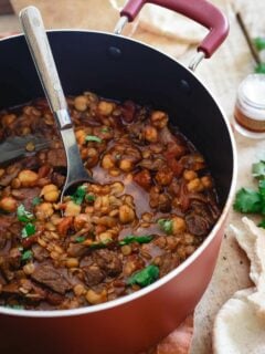 This lamb lentil stew is flavored with Moroccan spices and beefed up with chickpeas. Serve with fresh cilantro and a dollop of yogurt for a hearty and comforting winter meal.