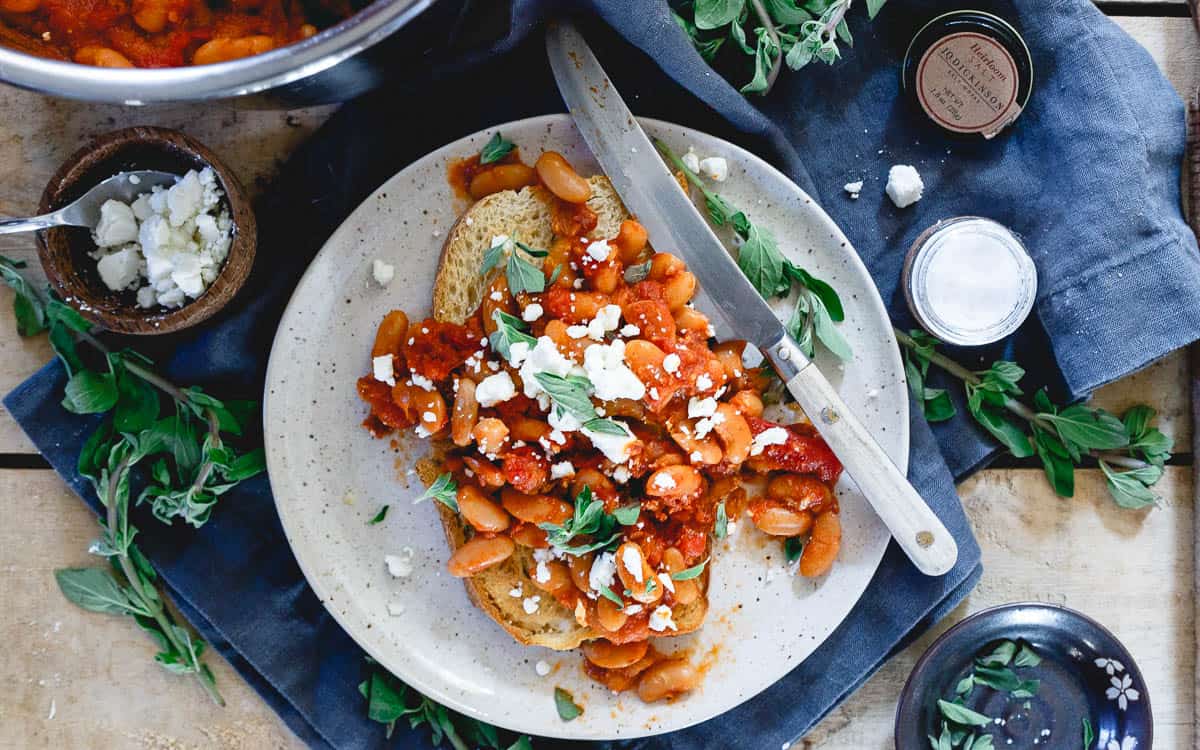 Toasted sourdough, hearty Instant Pot tomato white beans, crumbled feta and fresh oregano make the perfect hearty winter meal.