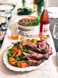 These grilled lamb chops are glazed with sweet peach honey and served with a simple watercress and grilled peach salad for the perfect summer meal.