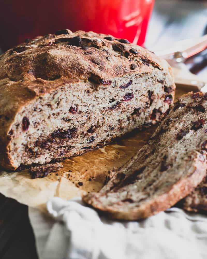 This Dutch oven bread is an easy no-knead bread that rises overnight and bakes right in the Dutch oven. It's loaded with cranberries, walnuts and dark chocolate and hints of cinnamon making it perfect for the holidays!