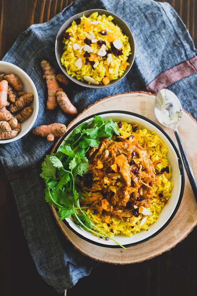 This Instant Pot coconut pork is cooked with turmeric, ginger, cinnamon and cardamom. It's aromatic, juicy and tender and perfect served over turmeric ginger rice with dried fruit and sliced almonds.