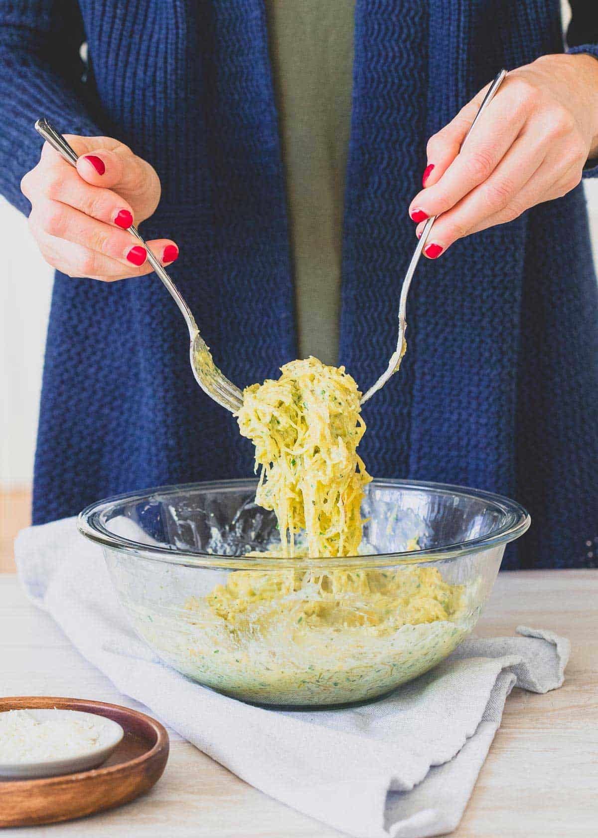 Lower carb spaghetti squash noodles are tossed with a simple basil pesto and creamy ricotta for an indulgent, healthier "pasta" meal.