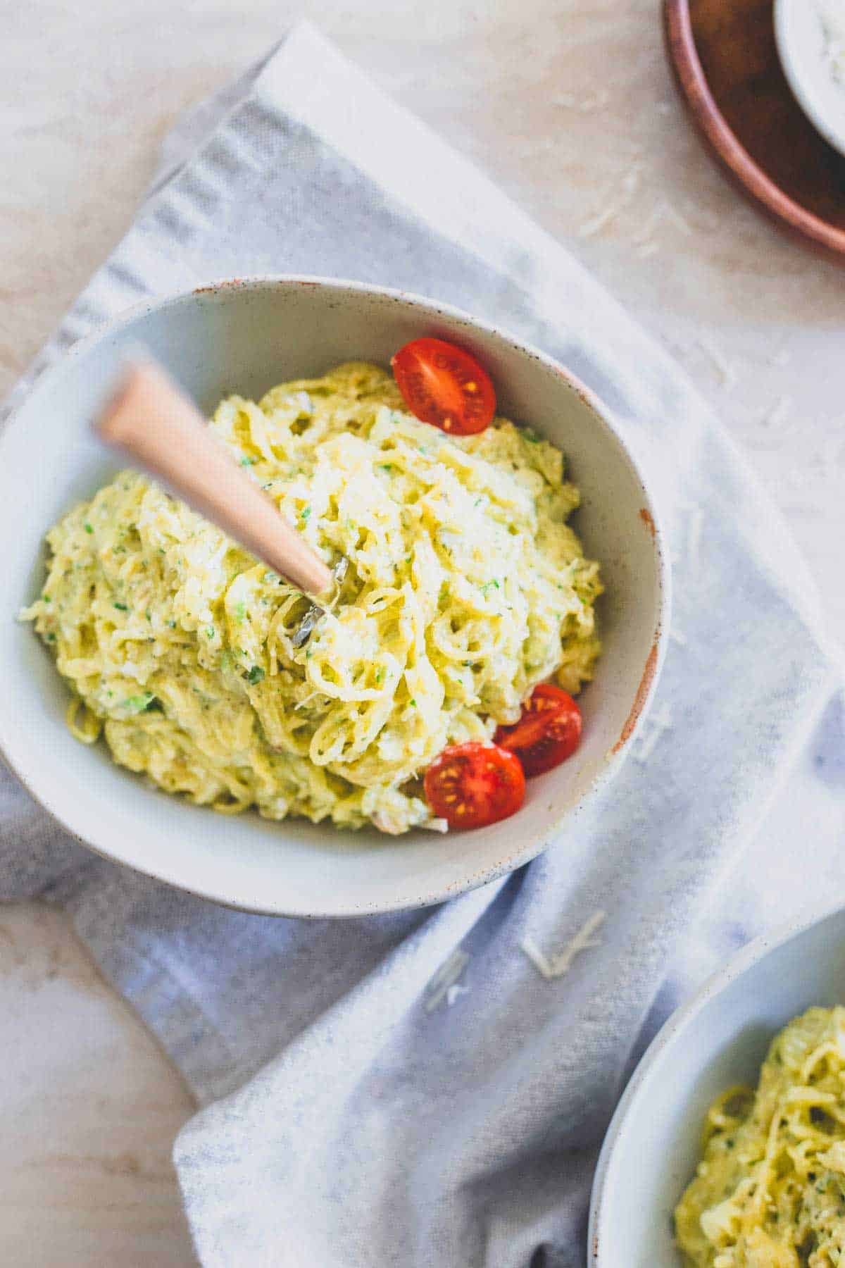 Pesto spaghetti squash noodles are mixed with creamy ricotta and cottage cheese for a healthy, indulgent faux-pasta dinner.