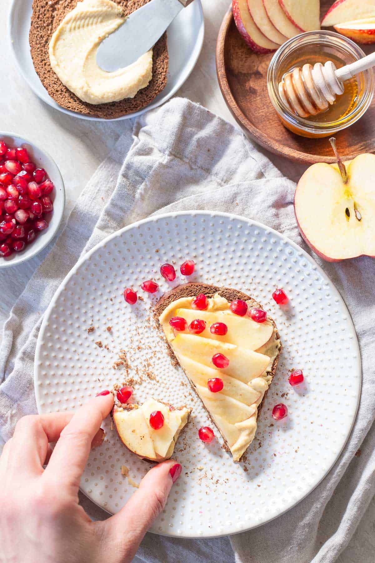 Quick and easy hummus toast with apple slices and fresh pomegranates is the perfect snack for winter.