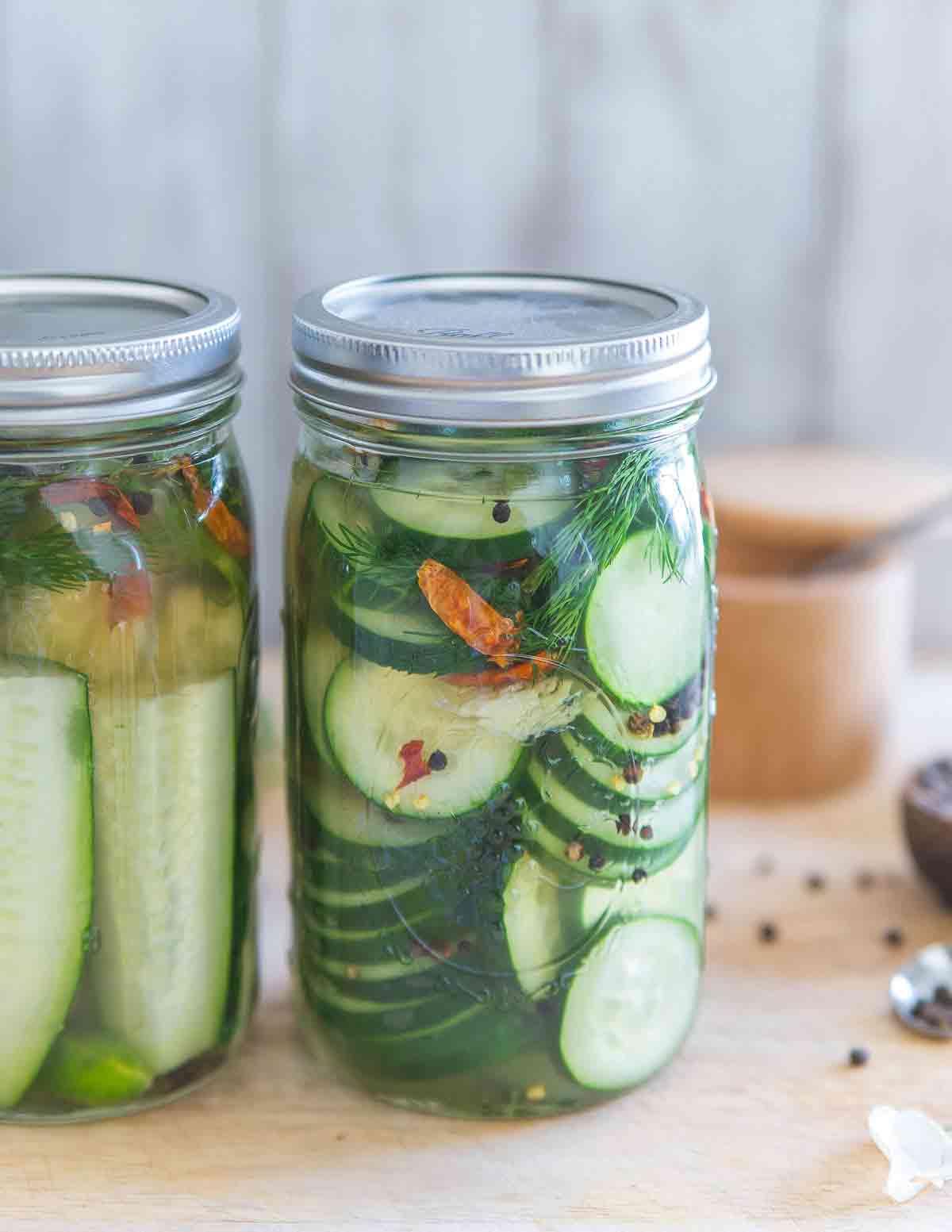 Make your own garlic dill pickles at home with this easy recipe, no special equipment needed! Option to make them spicy with the addition of dried chilis.