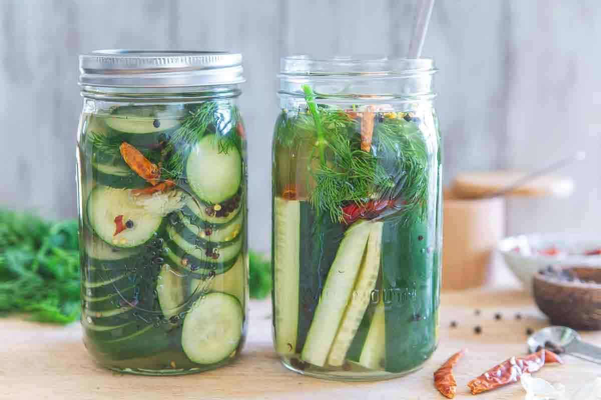 Spicy dill garlic pickles in two mason jars.