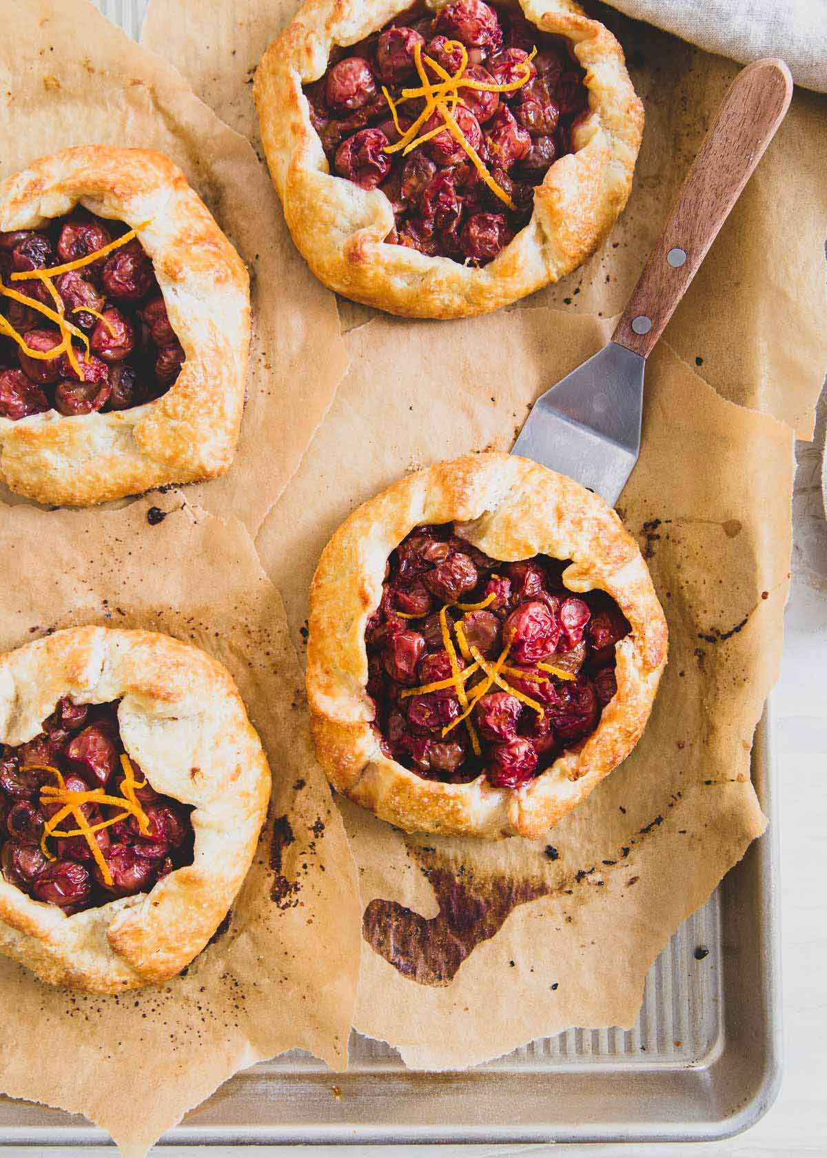 Tart cherries are brightened with fresh orange zest in these mini galettes for a rustic and delicious dessert.