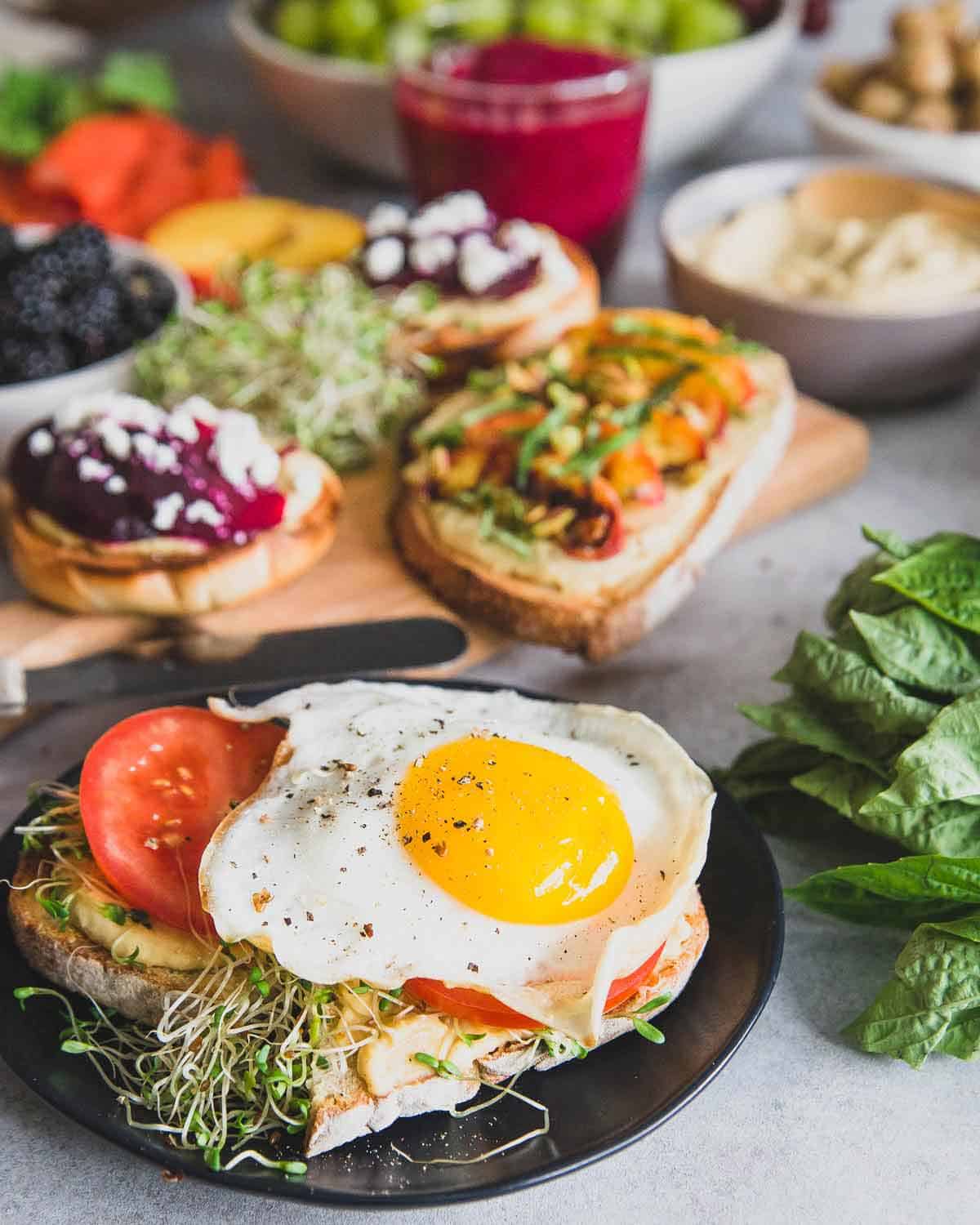 Hummus sourdough toast with sprouts, tomato and a fried egg is the perfect savory bite with this easy beet smoothie.