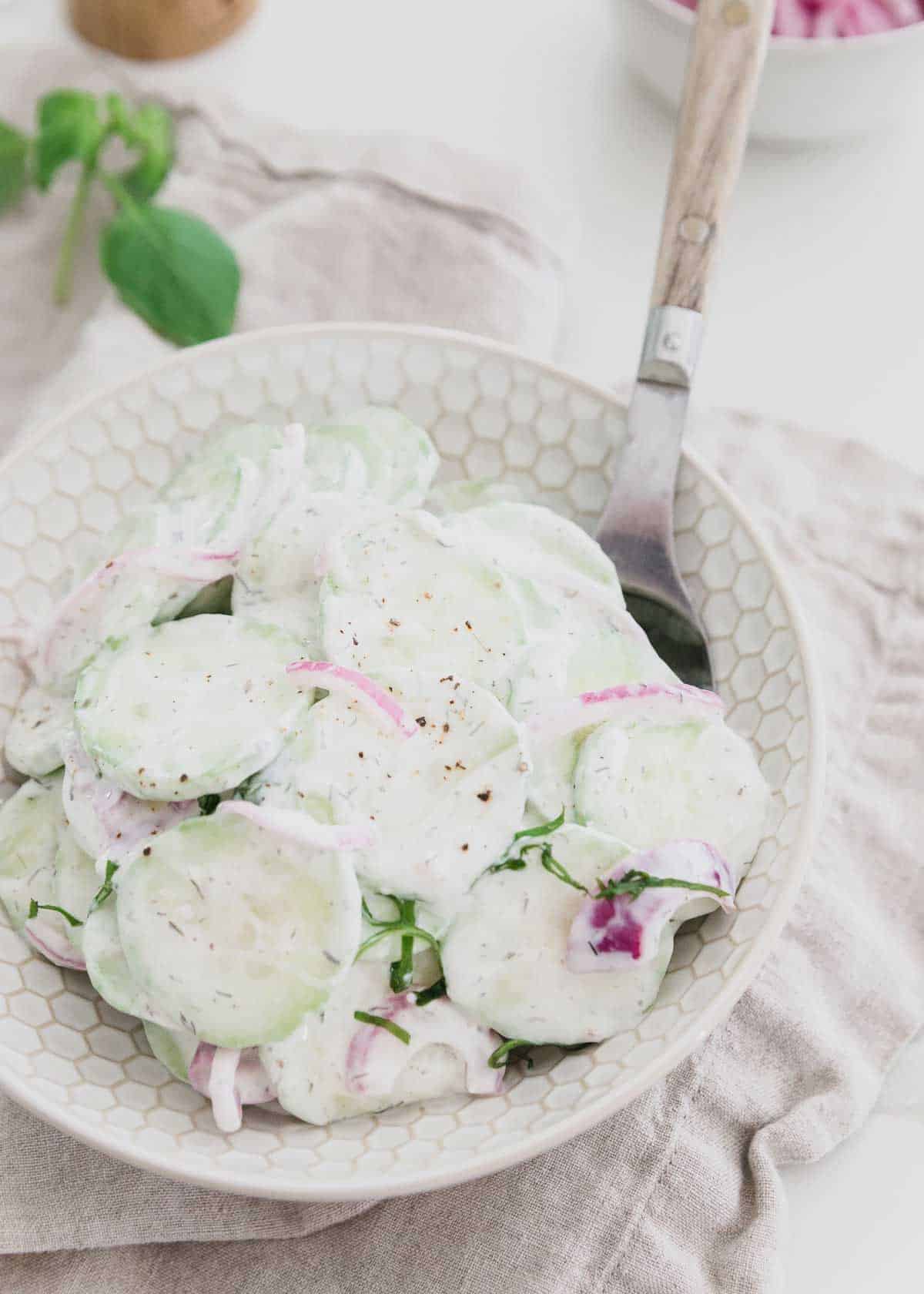 A healthier twist to the classic creamy cucumber salad recipe with quick pickled red onions. The perfect summer salad for any cookout!