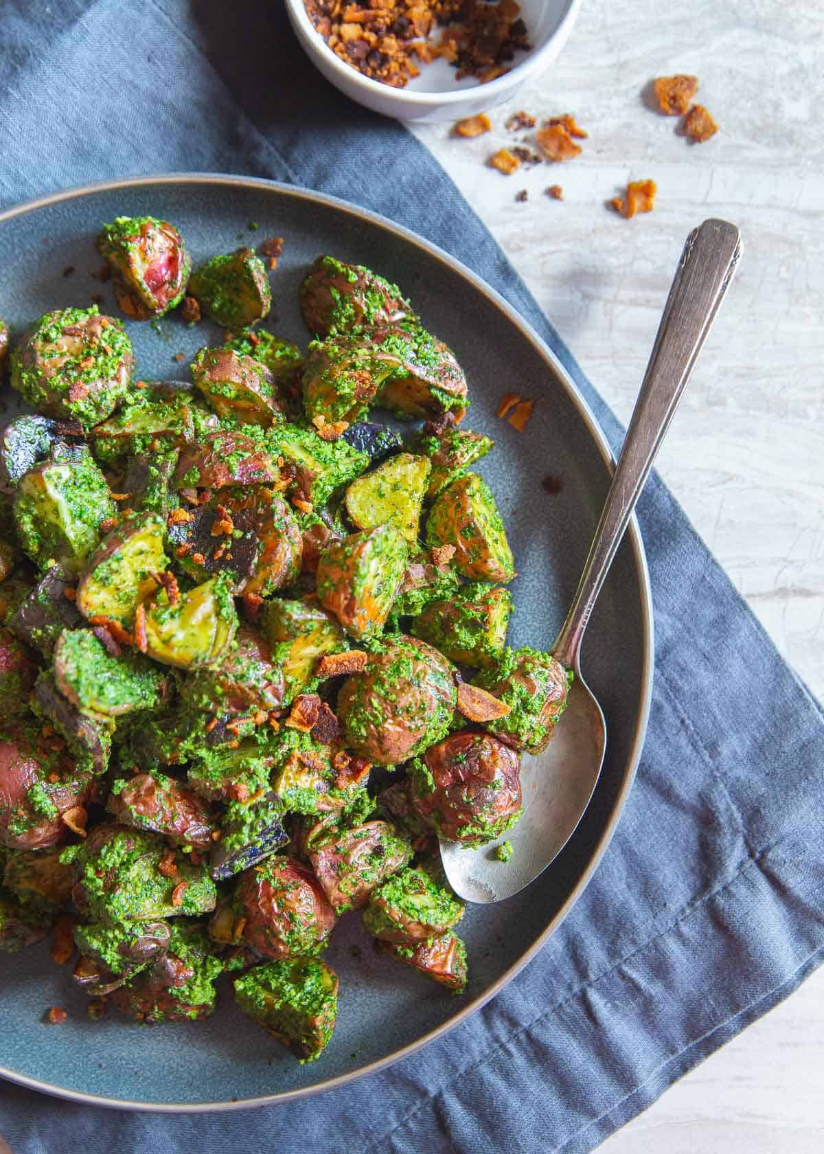 These easy roasted pesto potatoes with optional crumbled bacon make the best easy side dish that goes perfectly with any meat or fish dinner.