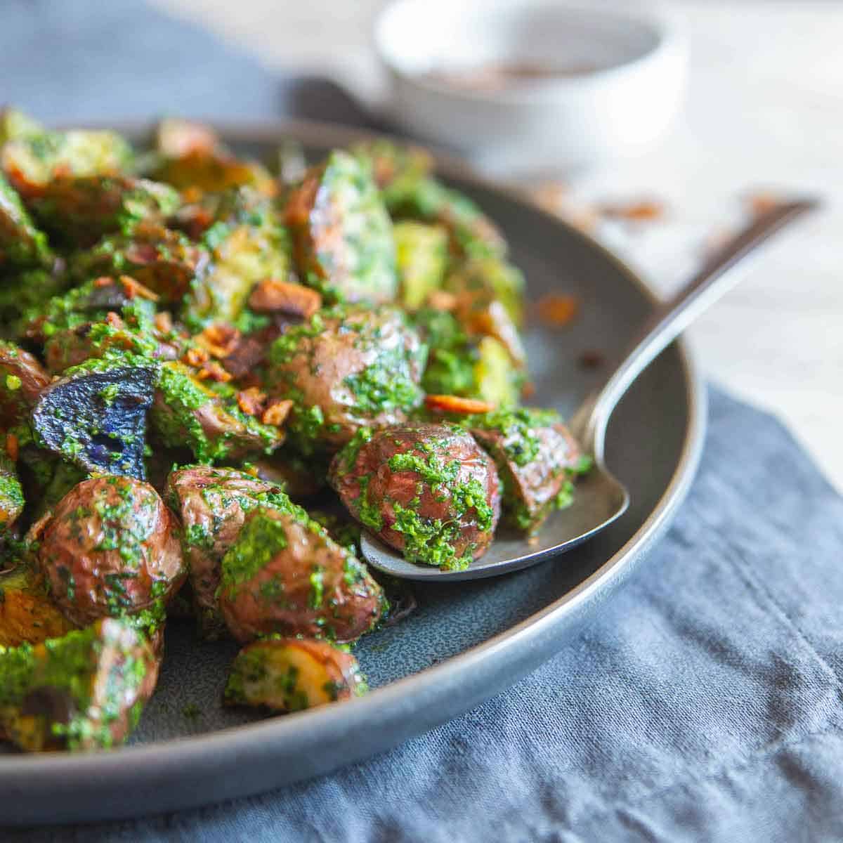 Crispy roasted potatoes with fresh pesto and salty bacon bits make this potato side dish a delicious option for almost any dinner.