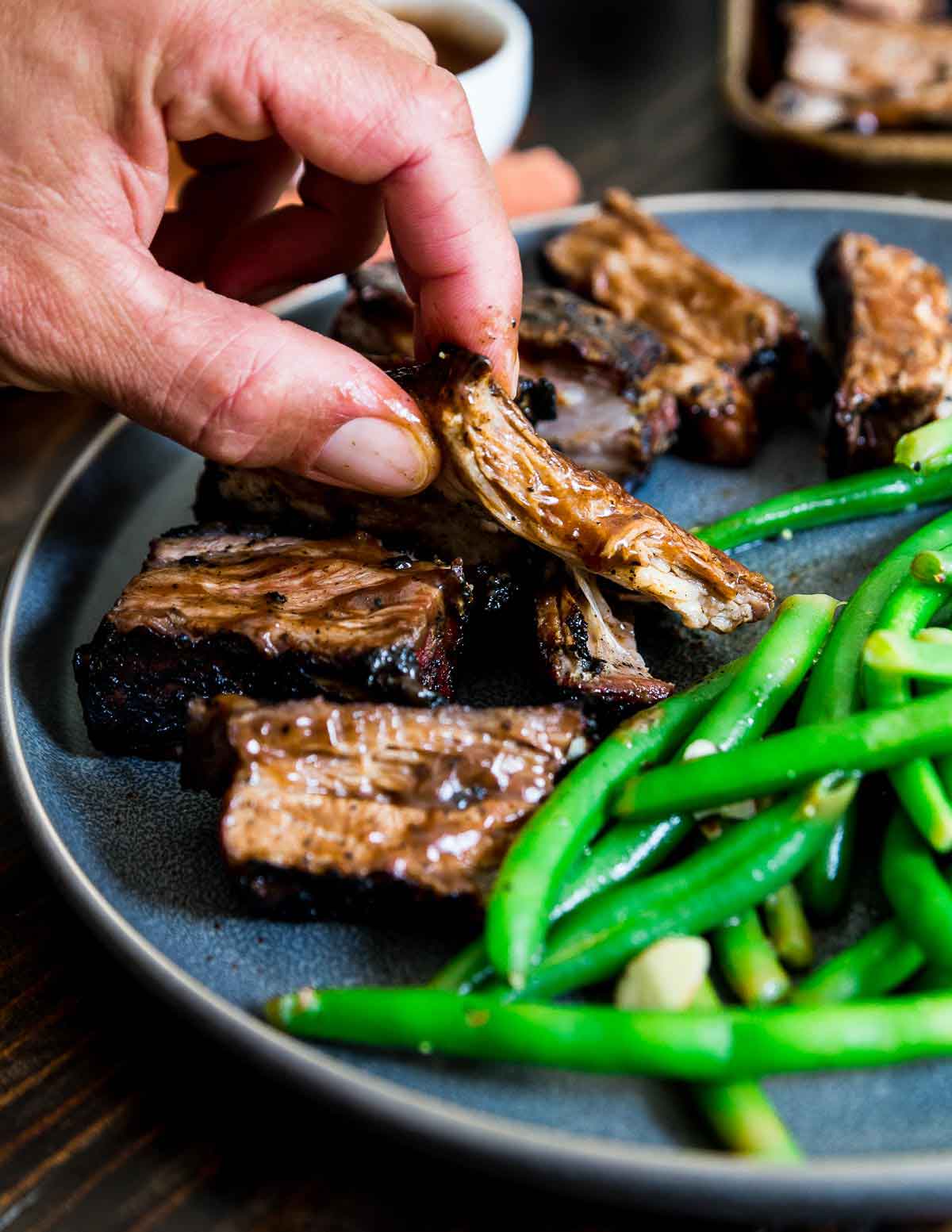 Slathered in BBQ spices and sauce, these grilled lamb riblets are a delicious summer meal.