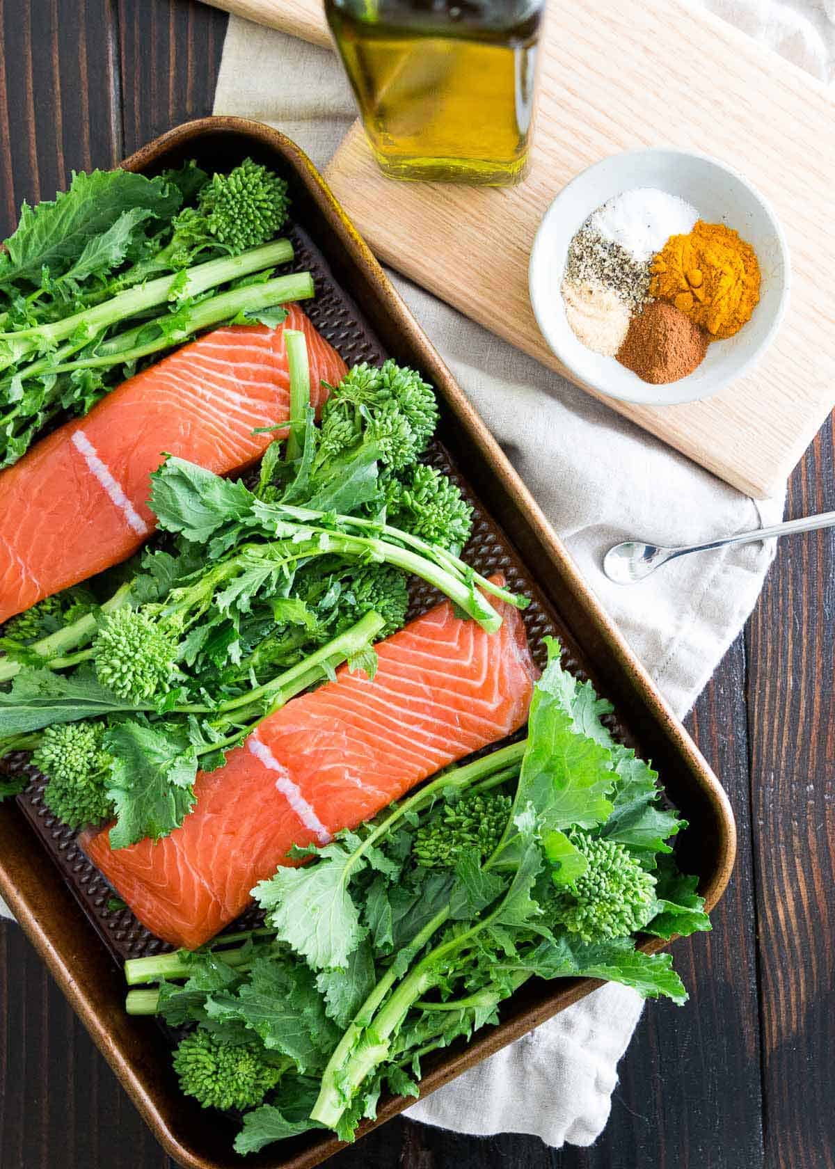 Wild salmon is cooked with broccoli rabe on one pan with a cinnamon turmeric spice mixture for a healthy and easy anti-inflammatory dinner.
