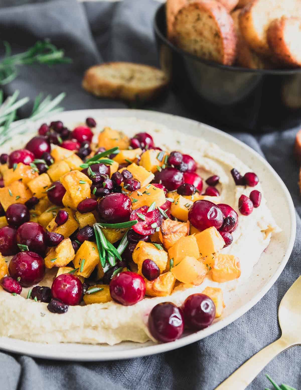 This butternut squash hummus makes a great holiday appetizer. With cranberries, pomegranates and rosemary, it's a festive and fun dish to share!