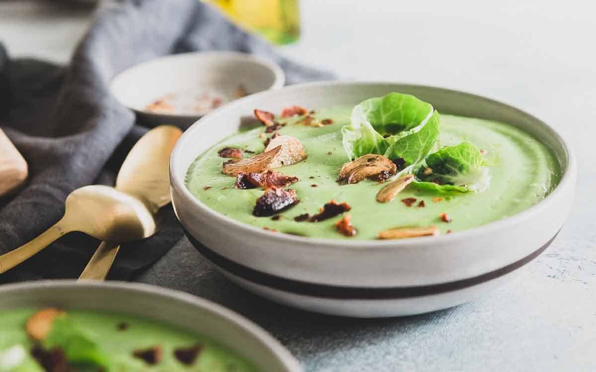 A healthy cream of Brussels sprout soup made with lots of garlic flavor and topped with crispy bacon for a delicious winter recipe!
