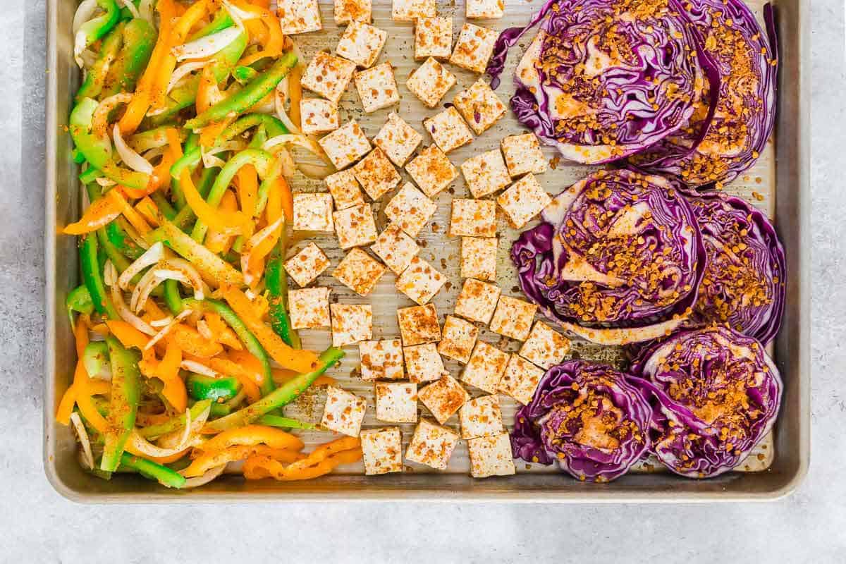 Sheet pan roasted tofu, red cabbage and mixed bell peppers and onions make an easy plant based meal prep option.