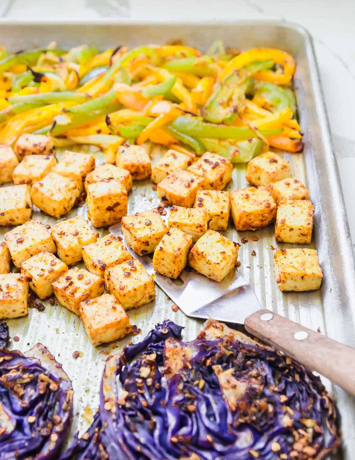 Extra firm roasted tofu with red cabbage, peppers and onions are meal prepped for easy lunches or dinners.