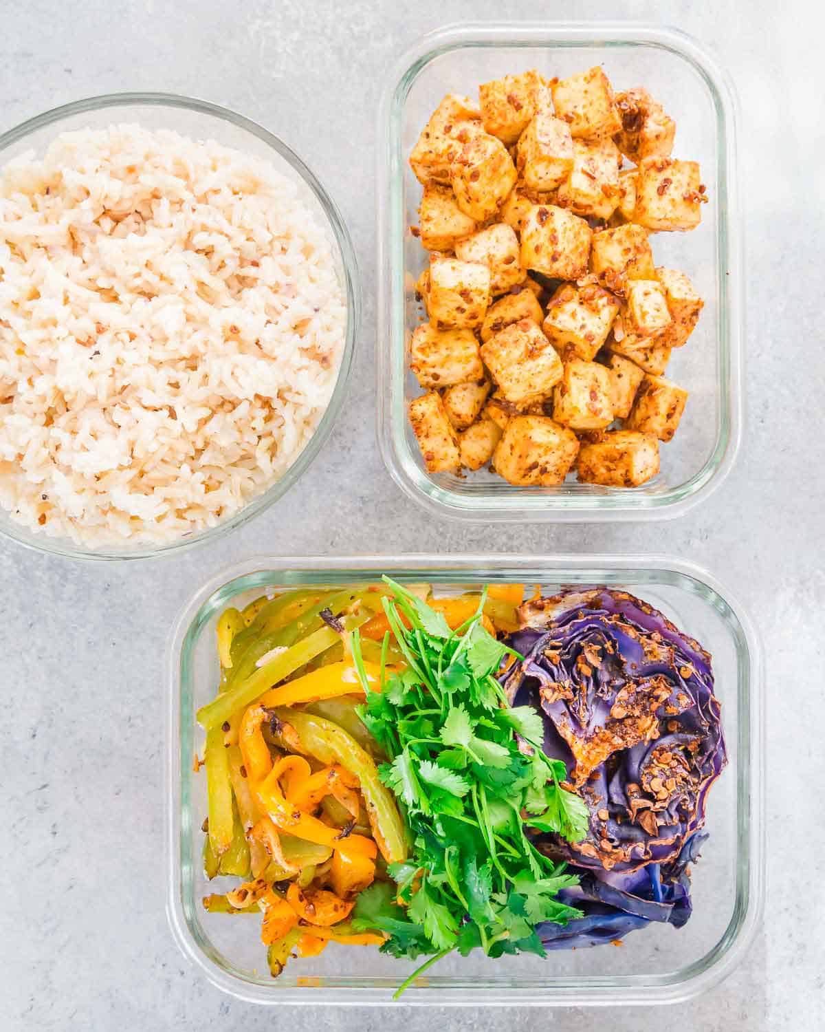 Roast tofu, cabbage, peppers and onions on a sheet pan and make brown rice for an easy plant based meal prep recipe idea.