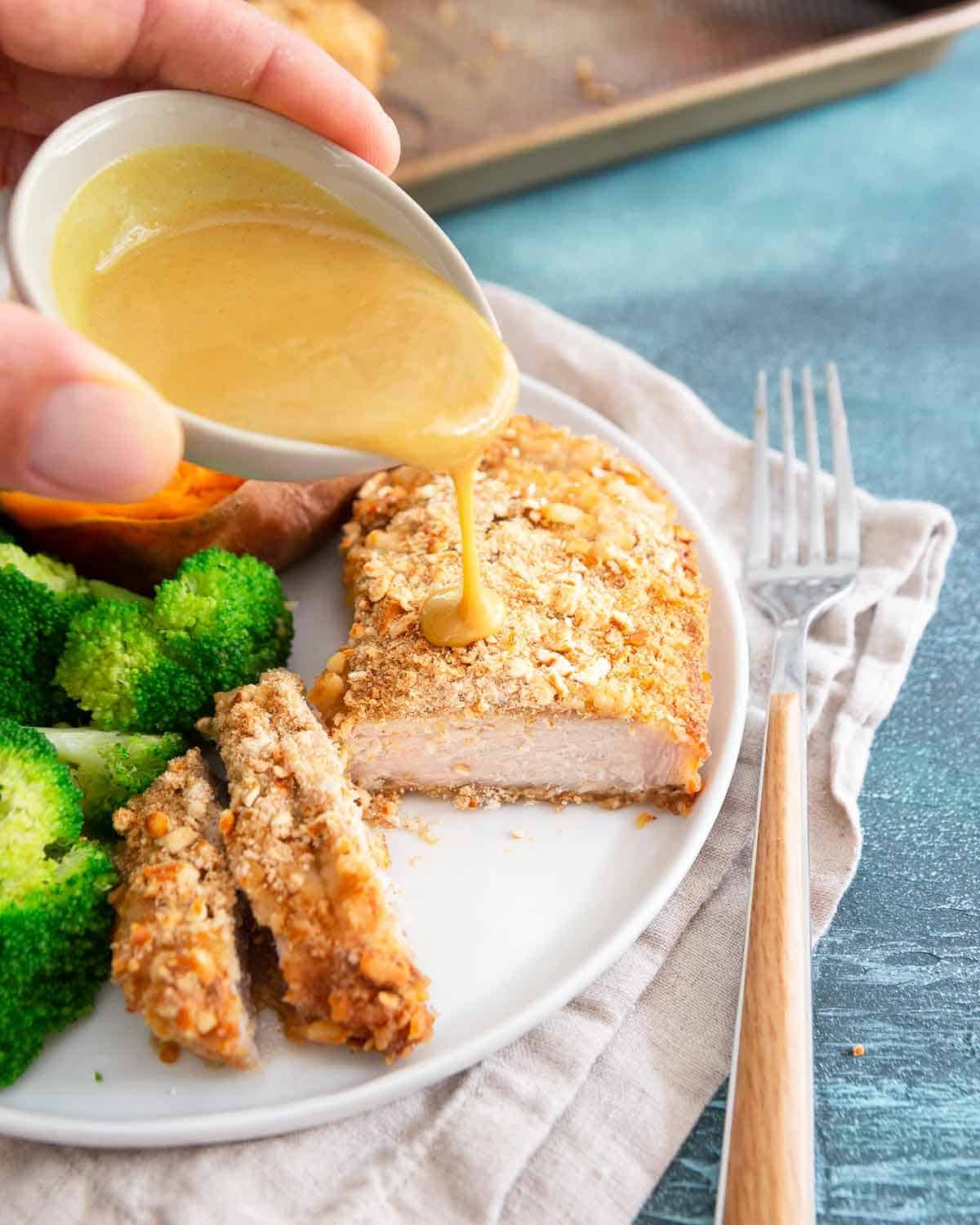 A quick maple dijon sauce goes perfectly with these easy baked pretzel crusted pork chops.