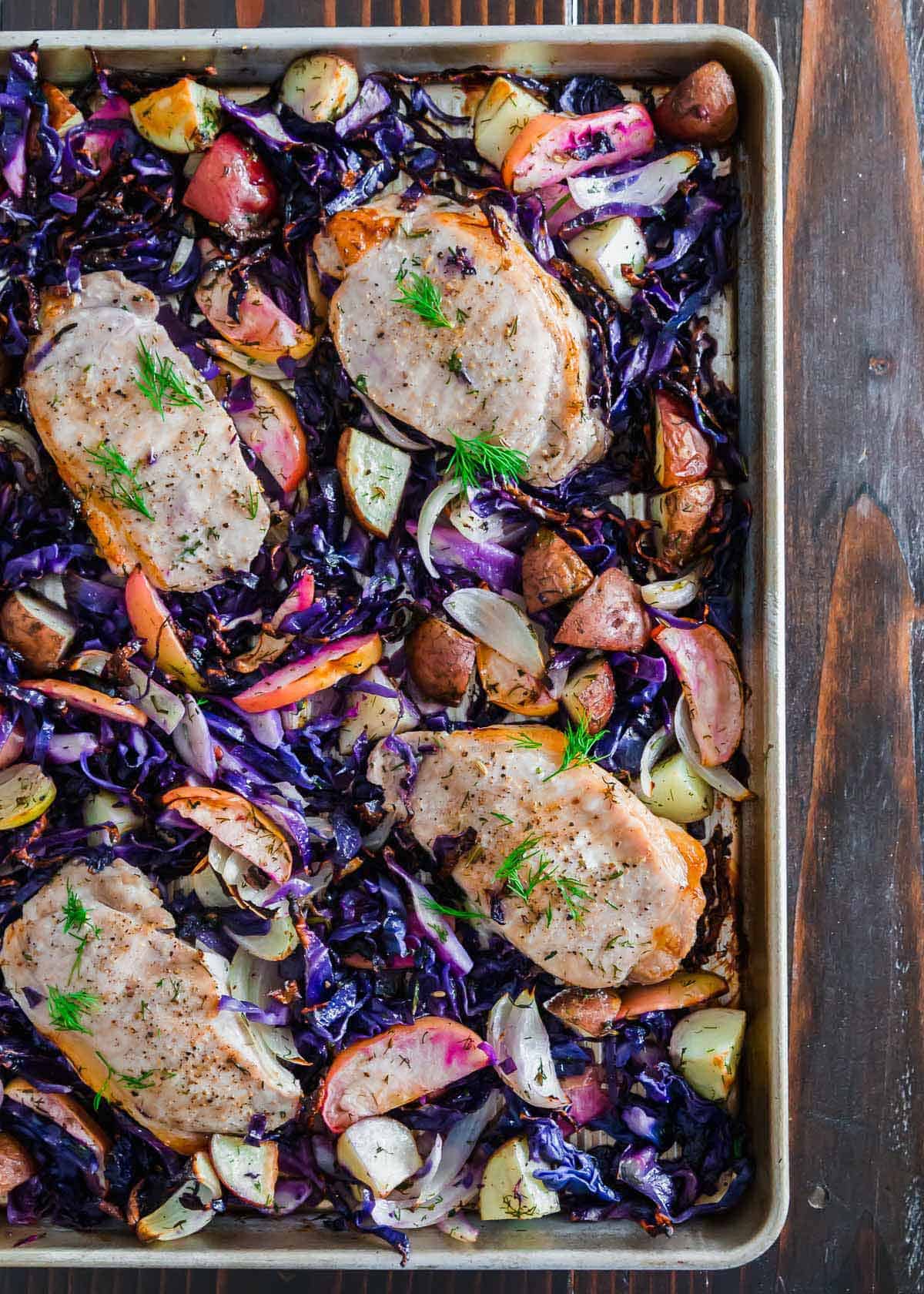 Roasted to perfection, these boneless pork chops with apples, potatoes and cabbage make a quick and easy weeknight sheet pan meal.