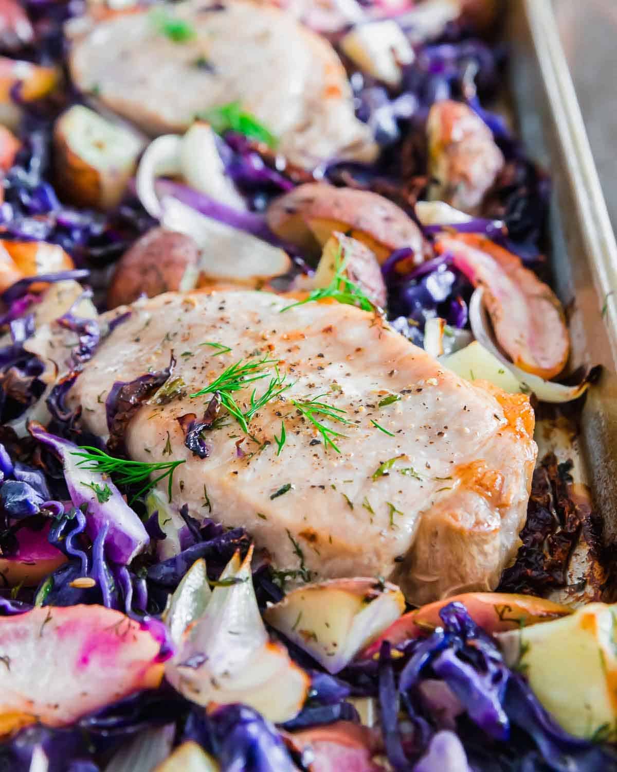 These quick and easy sheet pan pork chops are served with red cabbage, potatoes and apples. It's an all in one meal great for hectic weeknights with just one pan to clean up afterwards - the perfect recipe!