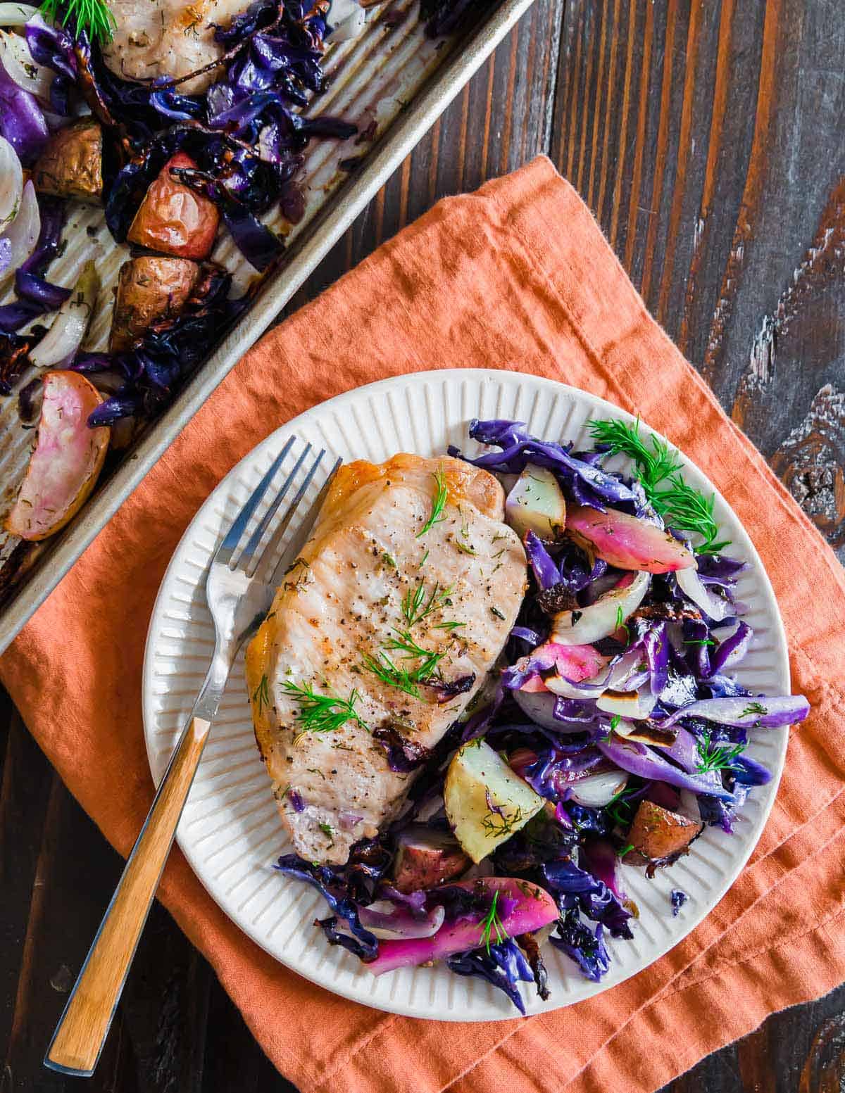 Juicy pork chops served with roasted potatoes, cabbage and apples is an easy and quick sheet pan meal.