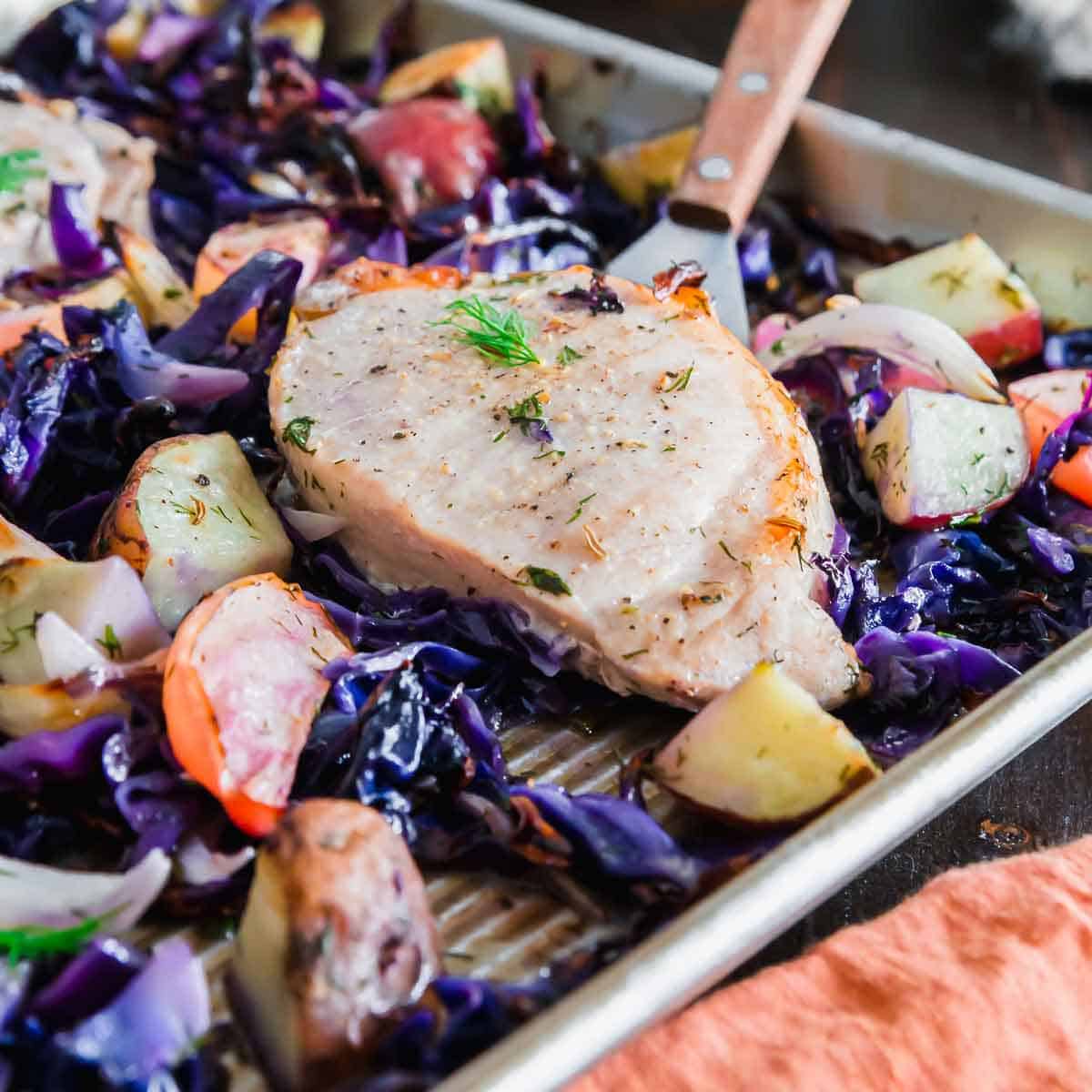 Cooking pork chops on a baking sheet along with all the sides at one time is the easiest way to make a complete dinner in no time.