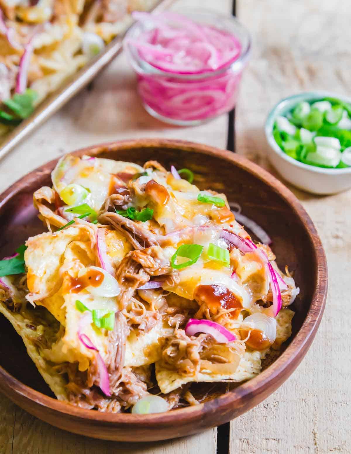 Cheesy BBQ pulled pork nachos are an easy, crowd pleasing recipe with your favorite pulled pork recipe.