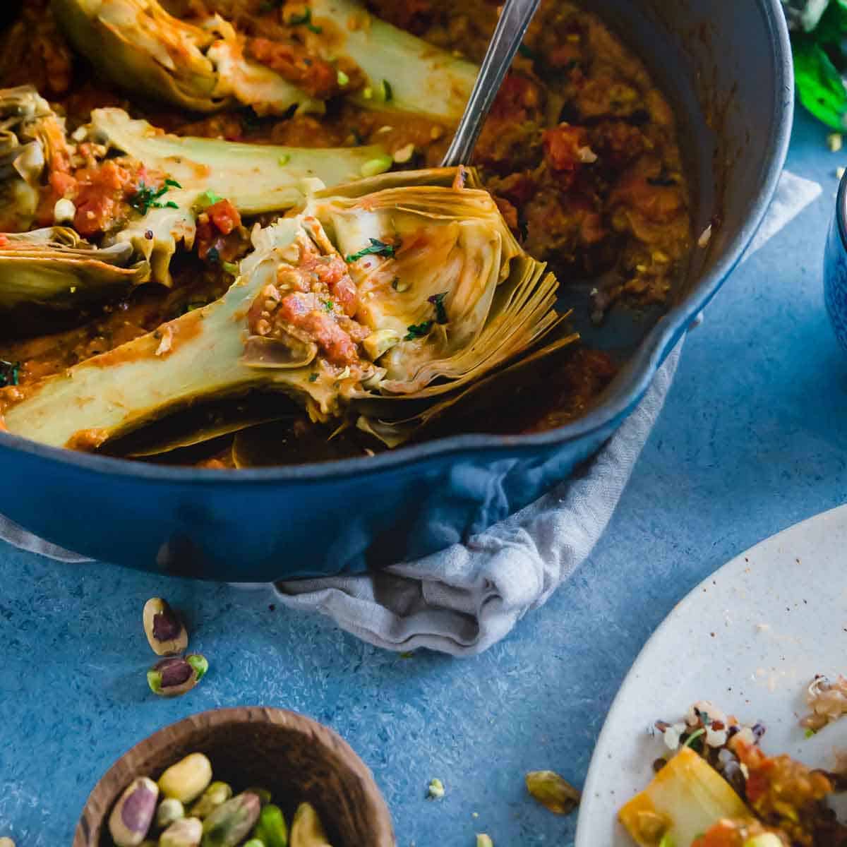 Once you braise artichokes, you'll never want to cook them another way again. Perfectly tender, full of flavor from reduced tomatoes, white wine and a deliciously nutty pistachio pesto.