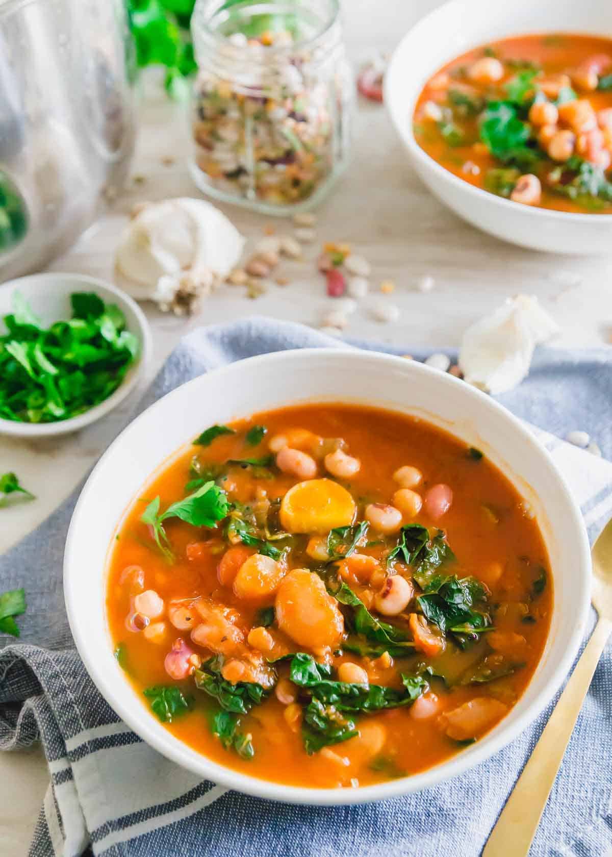 This Instant Pot bean soup recipe uses a 13 bean and lentil blend with a hearty tomato base for a cozy vegan meal. Tuscan kale leaves are stirred in at the end for added color and nutrition.