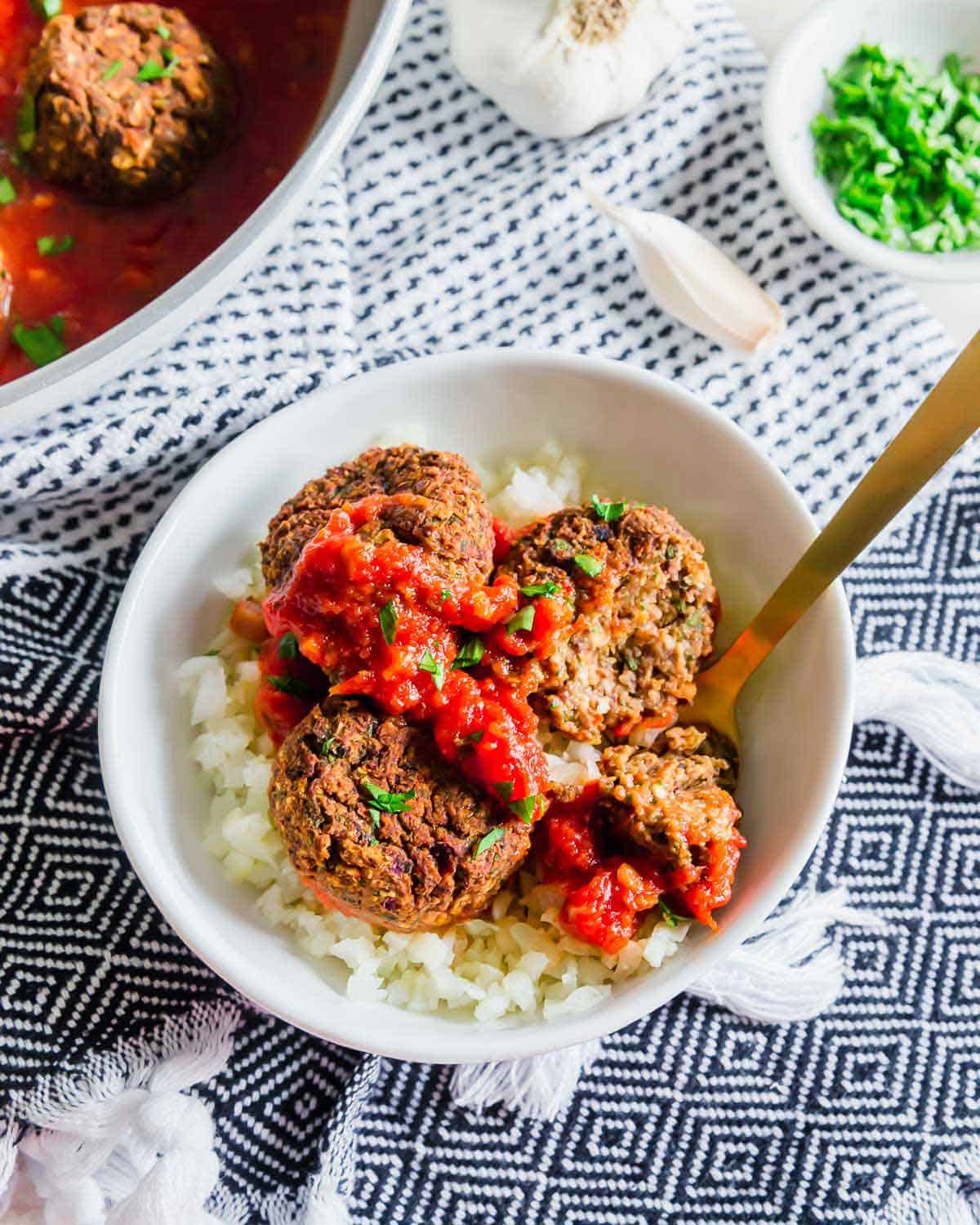 Enjoy these plant based black bean meatballs simmered in tomato sauce over zoodles, pasta or even cauliflower rice for a hearty and comforting meal.