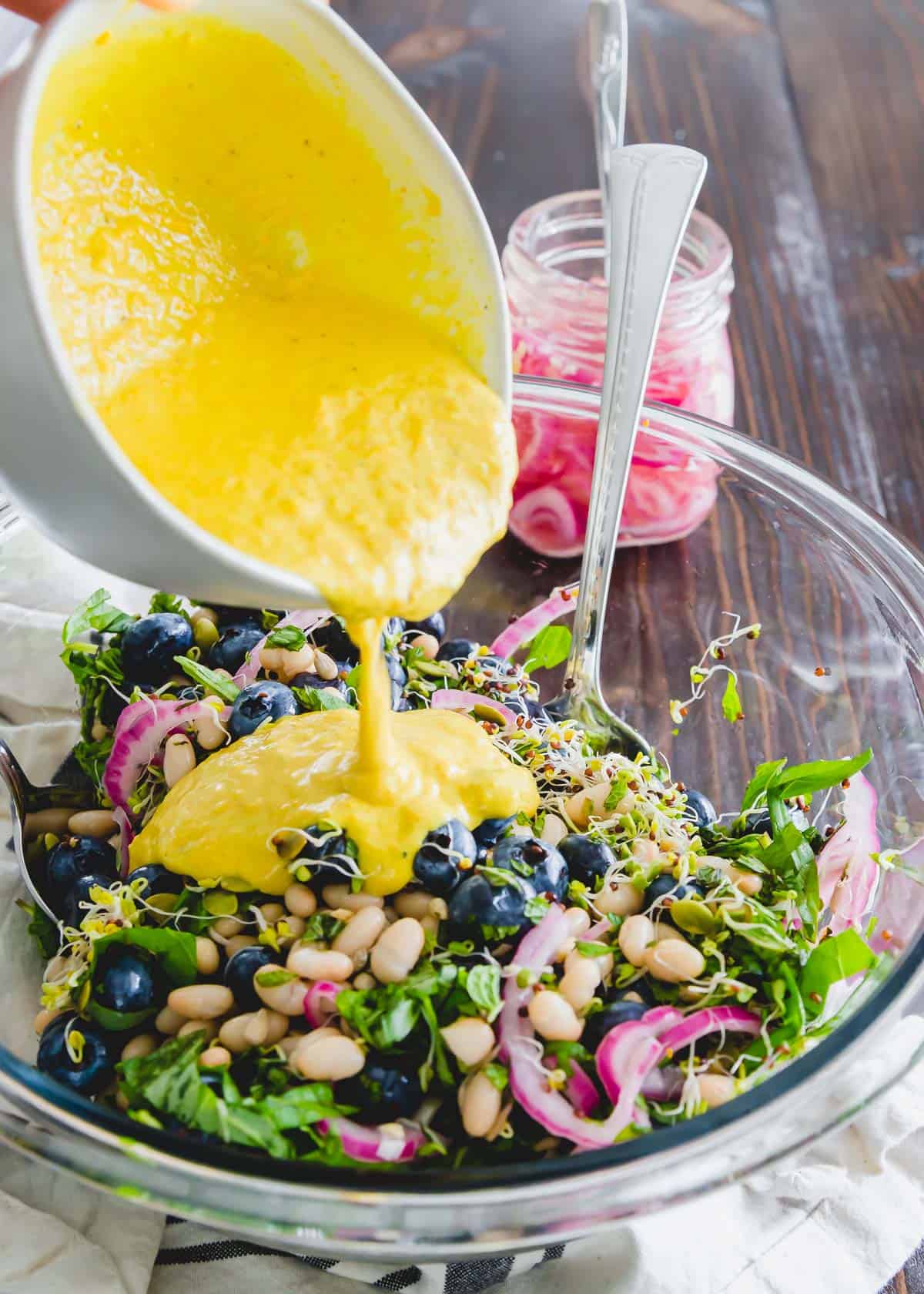 This blueberry white bean salad is tossed with a golden turmeric tahini dressing for a deliciously healthy side dish or plant based meal.